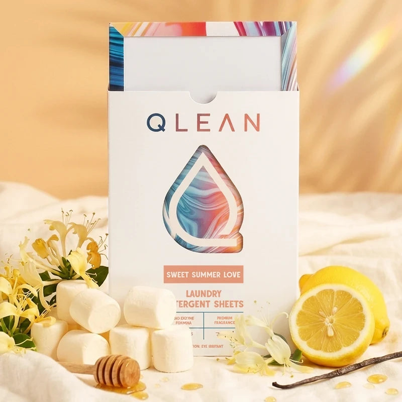 QLEAN Sweet Summer Love laundry detergent sheets box surrounded by honeysuckle, lemon, marshmallows and vanilla pod