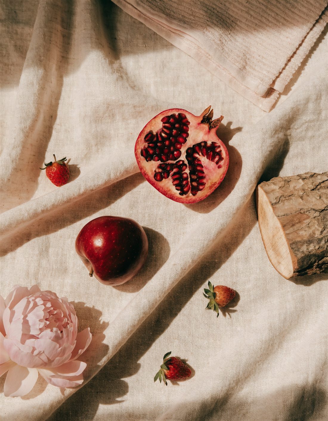 The Ruby Sunset Bliss scent notes: pomegranate, red apple, strawberry and peony on warm linen